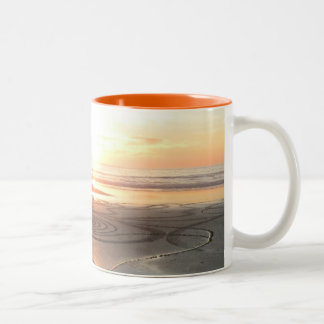 Círculo da areia na caneca do por do sol