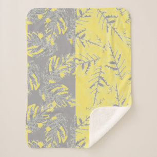 Cobertor Sherpa Cinzas e folhas amarelas sobre fundo listrado.