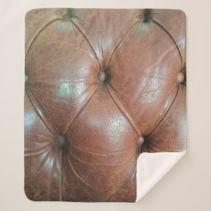 Cobertor Sherpa Luz na superfície do sofá de couro castanho, textu