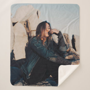 Cobertor Sherpa Sentada e sorridente vestindo calças pretas