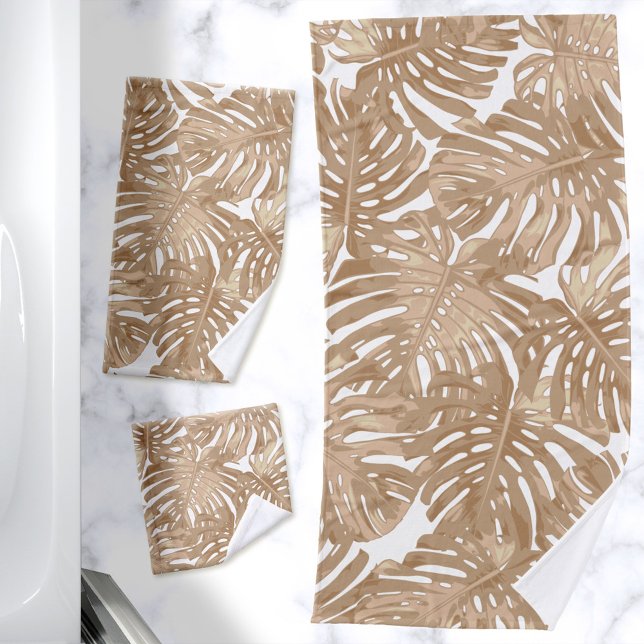 Conjunto De Toalhas Folhas Tropicais de Boho Castanho (Bath towel set with a print of light brown palm leaves on a white background)
