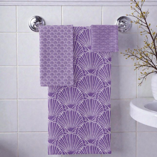 Conjunto De Toalhas Padrão De Shell Do Mar Branco Sobre Casa De Praia  (Seashell pattern bathroom towel set hanging on a rack on a bathroom wall.)