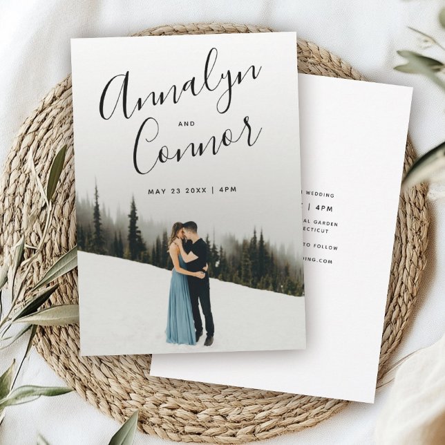 Convite Script Moderno de Foto | Casamento simples e limpo (Wedding invitation with a couple embracing on snowy ground, framed by tall evergreens. )