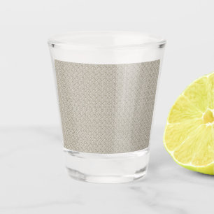 Copo De Shot um fundo bege com um padrão de quadrados pequenos