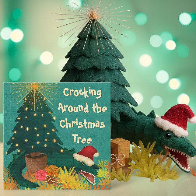 Cruzando ao redor do Natal (Funny Christmas card with a crocodile in a Santa hat under a tree and the pun Crocking Around)