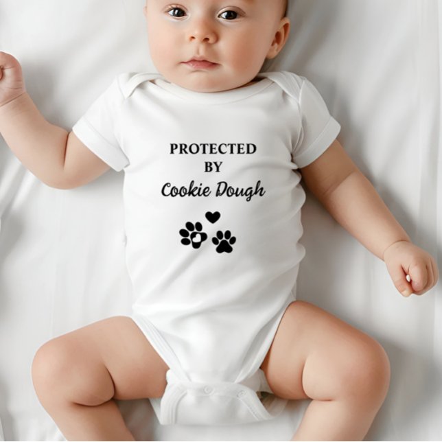 Cuja proteção é personalizada por cão (Adorable baby bodysuit with "Protected by (Dog's Name)" design, featuring hearts and paw prints.)