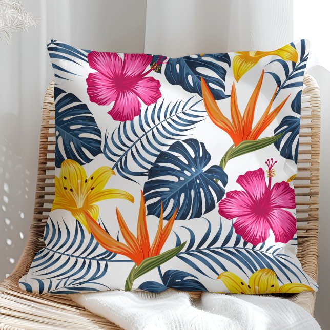Desenho tropical colorido em uma almofada branca (Colorful tropical design on a white pillow in a sunny rattan armchair.)