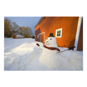 Foto Boneco de neve na frente do celeiro vermelho em