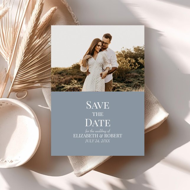 Foto personalizada azul moderno Salve o cartão de  (Modern Dusty Blue Custom Photo Save the Date Card on a neutral boho table with dry palm leaf.)