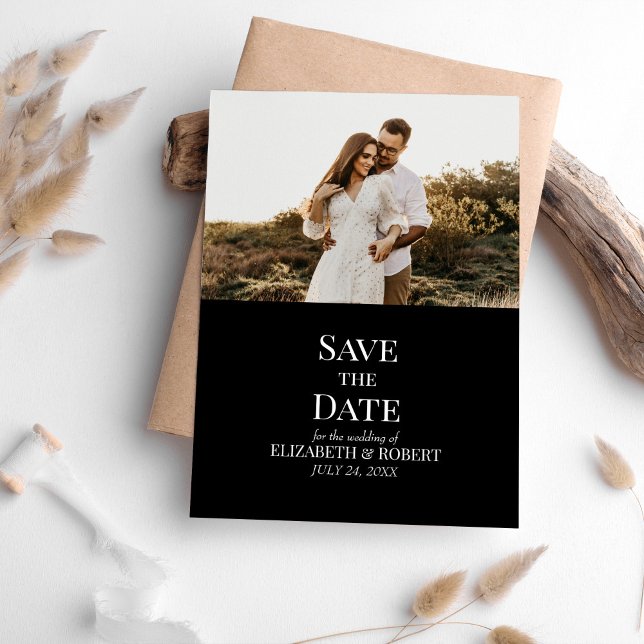 Foto personalizada em preto moderno Salve o cartão (Modern Black Custom Photo Save the Date Card on a table with neutral boho decoration.)