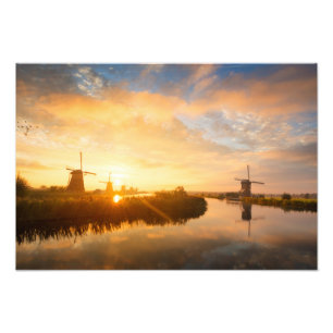 Foto Sol sobre moinhos de vento e um rio na Holanda