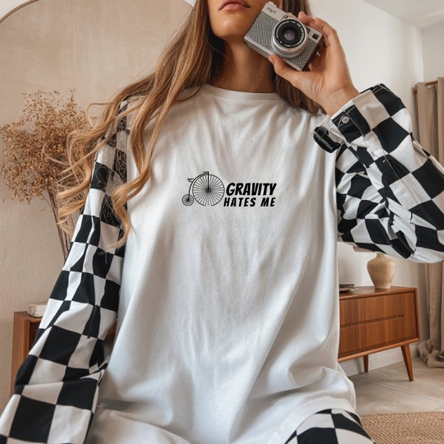 Garota de bicicleta retrô Ironia preta (This women's shirt features a retro bike graphic paired with the humorous phrase "Gravity Hates Me" )
