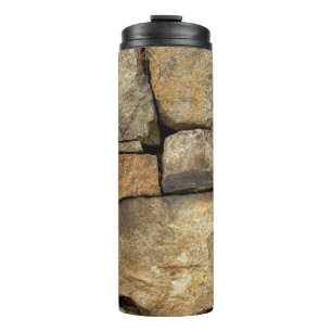 Garrafa Térmica A stone wall made of cobblestones background textu