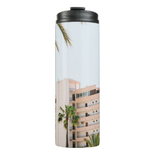 GARRAFA TÉRMICA EDIFÍCIO DE CONCRETO BRANCO AO LADO DA ÁRVORE DE