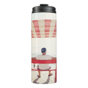 Garrafa Térmica Homem sentado no banco perto da praia