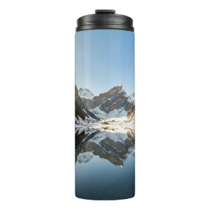 GARRAFA TÉRMICA MONTANHA BRANCA E MARROSA SOB PELE AZUL DURANTE O