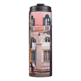 GARRAFA TÉRMICA MULHER DE CAMISA BRANCA E CALÇAS NEGRAS CAMINHANDO