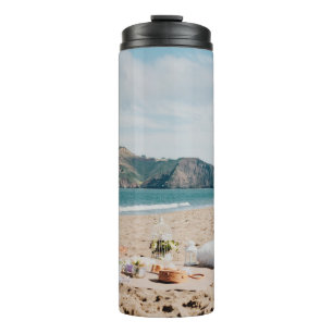 Garrafa Térmica Mulher sentada perto da costa enquanto olha para G