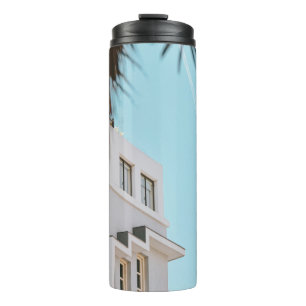 Garrafa Térmica Palmeira perto do prédio de concreto branco