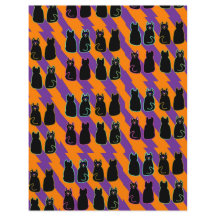 Gato preto em páginas de listras laranja e roxo
