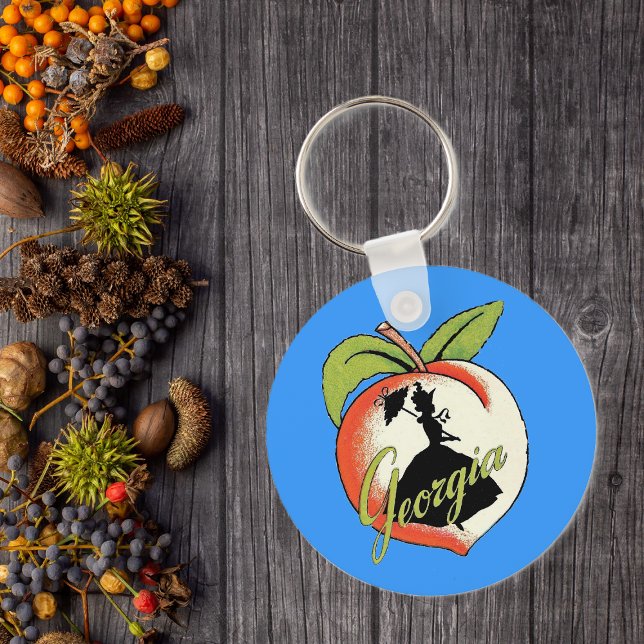 Georgia Peach Chaveiro (Southern bell lady silhouette on peach with Text Georgia on vibrant blue keychain.)