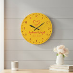 Grande Relógio de Presente de Casamento ou Aniversário Am<br><div class="desc">Ideia de presente de casamento ou aniversário personalizado: um relógio de parede amarelo personalizado minimalista e encantador. O design inclui os nomes do casal e a data do casamento. O relógio é decorado com uma ilustração de coração simples como símbolo de amor.</div>