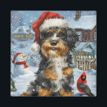 Imã Bernedoodle Dog Winter Wonderland Christmas<br><div class="desc">Este design festivo captura o espírito alegre da época de férias, apresentando um adorável filhote vestindo um chapéu de Papai Noel. O cachorro está aninhado numa terra maravilhosa de inverno, completo com um boneco de neve, uma árvore de Natal decorada, e presentes lindamente envoltos. Os flocos de neve caem suavemente,...</div>