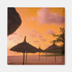 Imã cabines de praia estilo Palapa ao nascer do sol, B