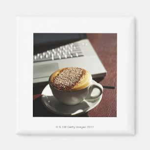 Imã Cappuccino na frente do laptop