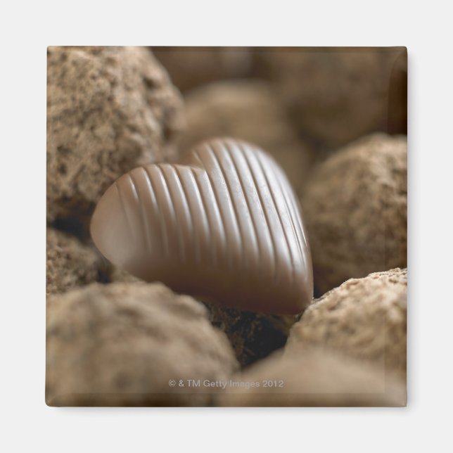 Imã chocolate aninhado entre outros chocolates (Frente)
