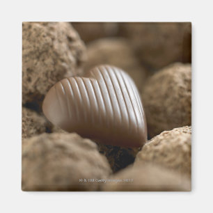 Imã chocolate nestled entre outros chocolates
