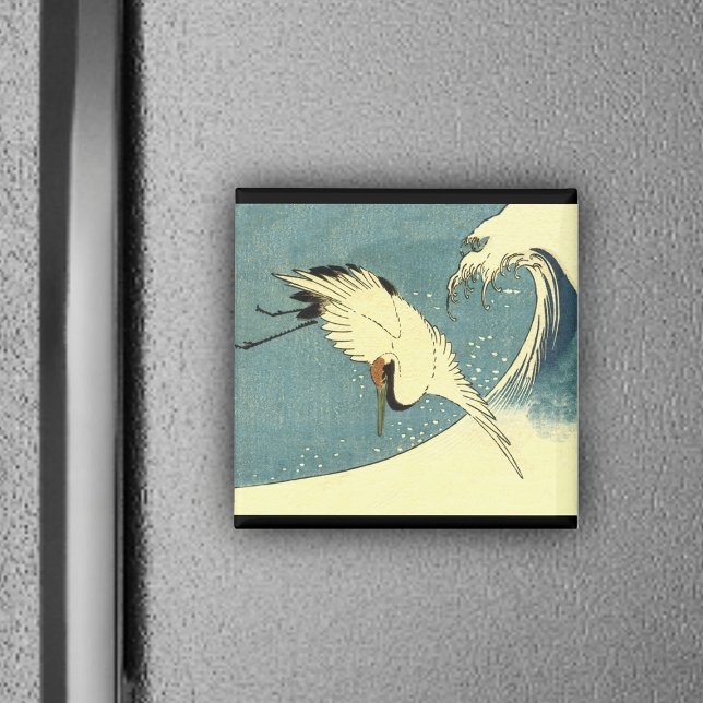 Imã Crane voando em uma onda (White crane bird flying over blue ocean wave black borders on magnet.)