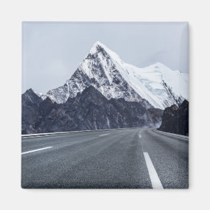 Imã Estrada asfaltada na frente da montanha da neve