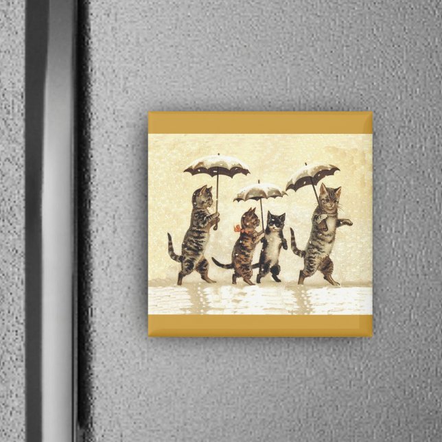 Imã Família de Gatos com Guarda-chuvas Andando na Neve (Four brown cats walking upright in snow with umbrellas on yellow square magnet.)
