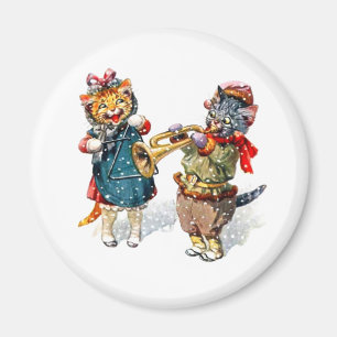 Imã Gatos bonitos tocam trompete e triângulo na neve