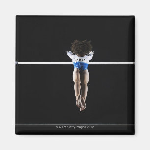 Imã Gymnast (9-10) que alcança para bares desiguais