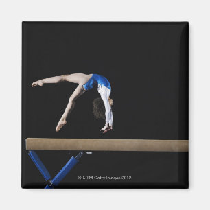 Imã Gymnast (9-10) que lança no feixe de equilíbrio,