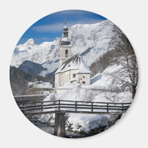 Imã Igreja na neve com montanhas alpes