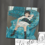 Imã Menina de uma cadeira azul | Mary Cassatt<br><div class="desc">A Menina em uma Cadeira Azul (1878), de Mary Cassatt, é um retrato impressionante de uma jovem que está soltando em uma cadeira de braço azul de tamanho gigante. A pintura captura um momento de relaxamento, com a criança se inclinando casualmente e exuando uma sensação de facilidade juvenil. Os tons...</div>