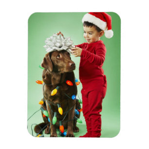 Ímã Menino novo que envolve luzes de Natal em torno de