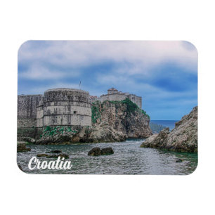 Ímã Muros de fortaleza, costa rochosa e mar na Croácia