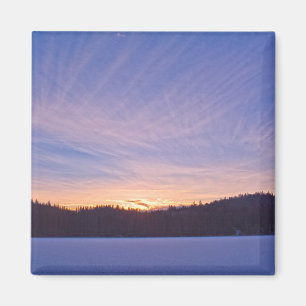 Imã Pôr do sol sobre lago e árvores de inverno coberta