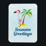 Ímã Sessões saudações Flamingo Rosa Rosa em Santa Hat<br><div class="desc">Festivo natal flex-magnet com o texto: Saudações de Seasons. Um desenho branco de um flamingo cor-de-rosa vestindo um chapéu de Santa vermelho. Em pé num monte de areia amarela da praia com uma palmeira de coco verde e marrom no fundo. Fundo azul claro. Design tropical festivo,  bonito e divertido.</div>