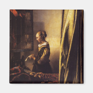 Imã Uma menina que lê uma letra em uma janela aberta