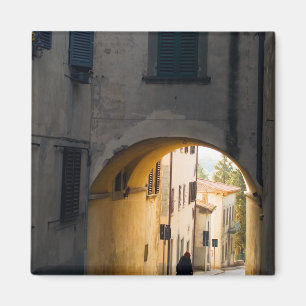 Imã Uma pessoa andando sob um arco, descendo uma colin