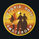 Imã Viagens vintage, Hotel Victoria, Amsterdã, Holanda<br><div class="desc">Ilustração vinda de arte de poster de viagens europeia do Hotel Victoria, Amesterdã, Holanda (Países Baixos), com um homem e uma mulher vestidos tradicionais e entupidos de visto. Um veleiro no oceano, um pôr do sol amarelo e um moinho de vento tradicional estão no fundo atrás de uma silhueta de...</div>