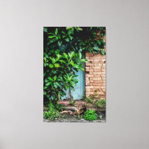 Impressão Em Tela Rustic Blue Door Behind Lush Green Foliage and Bri