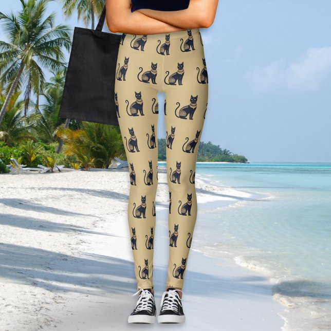 Legging Padrão de Gato Preto Egípcio Cor de Areia (A pair of leggings in sand beige, with Egyptian-inspired black and faux gold cat pattern)