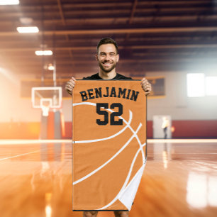 Mão o basquetebol ostenta a toalha, toalha de banho do