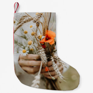 MEIA DE NATAL PEQUENA PESSOA QUE POSSUI FLORES DE LARANJA